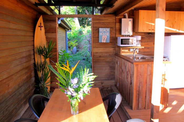 Salle à manger avec salon et cuisine sur la terrasse du Bungalow Anuhe