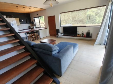 Large living room with corner sofa, home cinema and its fully equipped kitchen