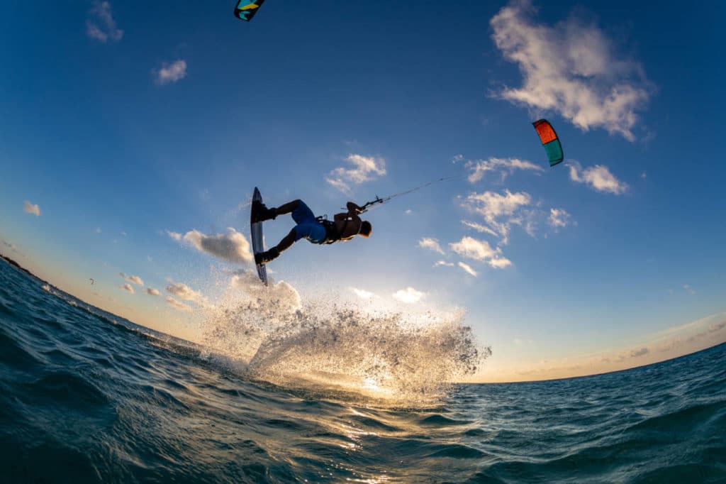 person riding a parachute and surfing at the same time in kitesurf. Tahiti, French Polynesia